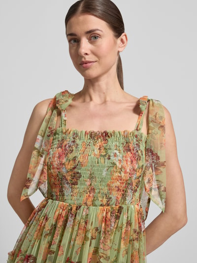 Vrouwenmodel draagt Cocktailkleid im Stufen-Look van LACE & BEADS in groene A-lijn met bloemenprint, smok-details, ruches van tule, close-up bovenlichaam.