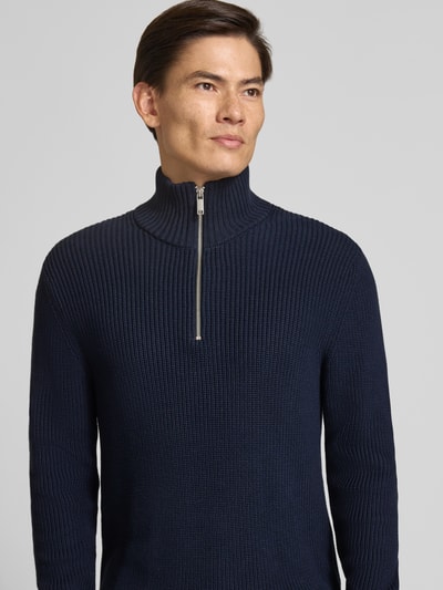 Männermodel trägt Slim Fit Strickpullover aus reiner Baumwolle mit Troyer-Kragen von MCNEAL in Dunkelblau, Nahaufnahme Oberkörper, gerippte Abschlüsse, langärmliges Design, Rückenlänge 72 cm, Ärmellänge 74 cm