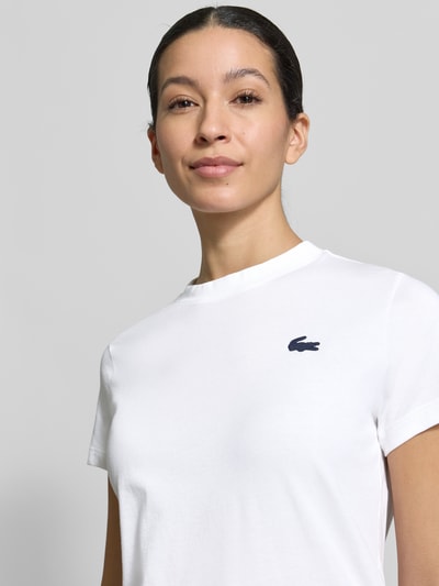 Modelka kobieca nosi Slim Fit T-Shirt aus Baumwoll-Mix od Lacoste Sport, kolor jednolity, logo, okrągły dekolt, krój slim fit, zbliżenie górnej części ciała.