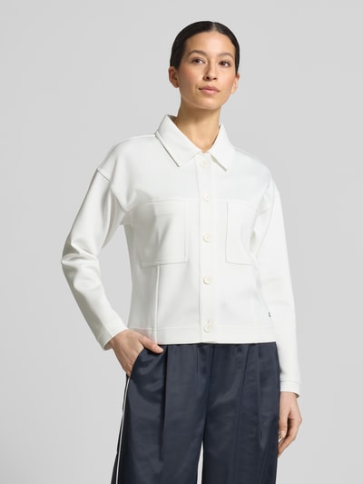 Frauenmodel trägt Jacke mit Umlegekragen und Brusttaschen von monari in Weiß, Regular Fit, Knopfleiste, glatte Struktur, Ganzkörperansicht von vorne.