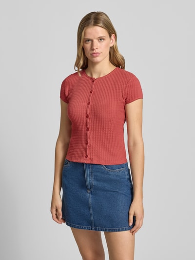 Frauenmodel trägt Slim Fit Damen T-Shirt mit durchgängiger Knopfleiste Modell 'AJOUR' von REVIEW aus Reine Baumwolle, kurzärmelig, Rundhalsausschnitt, Rückenlänge bei Größe S 49 cm, Ganzkörperansicht von vorne.