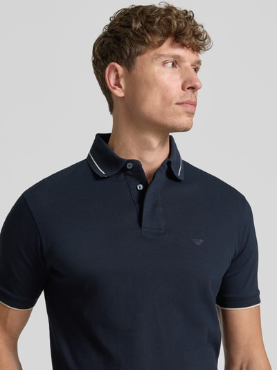 Männermodel trägt Slim Fit Poloshirt mit Label-Stitching von Emporio Armani aus Reine Baumwolle, verdeckte Knopfleiste, Nahaufnahme Oberkörper. Rückenlänge bei Größe M: 68 cm.