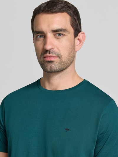 Männermodel trägt T-Shirt mit Rundhalsausschnitt und Label-Stitching von Fynch-Hatton in Grün, reine Baumwolle, Regular Fit, Nahaufnahme Oberkörper.