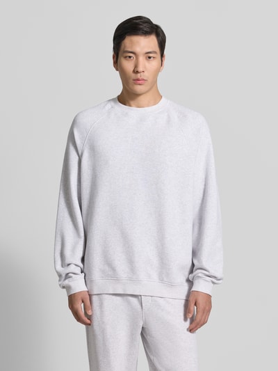 Männermodel trägt Sweatshirt mit Rundhalsausschnitt Modell 'ATUBAY' von American Vintage aus Baumwoll-Elasthan-Mix, hellgrau, Relaxed-Fit, Ganzkörperansicht von vorne. Rückenlänge 67 cm, Ärmellänge 77 cm bei Größe M/L.