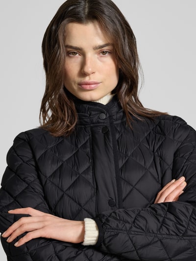Vrouwenmodel draagt Straight Fit Steppmantel Modell 'Philia' van CINQUE in zwart met doorgestikte look, staande kraag en drukknoopsluiting, Nahaufnahme Oberkörper.