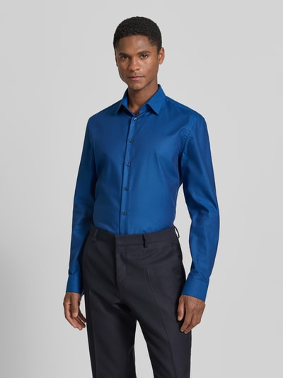 Männermodel trägt Slim Fit Business-Hemd mit Kentkragen von Jake*s in Blau, Reine Baumwolle, Knopfleiste, Sportmanschetten, abgerundeter Saum, Rückenlänge 79 cm, Schulterbreite 48 cm, Ärmellänge 65 cm, Ganzkörperansicht von vorne.