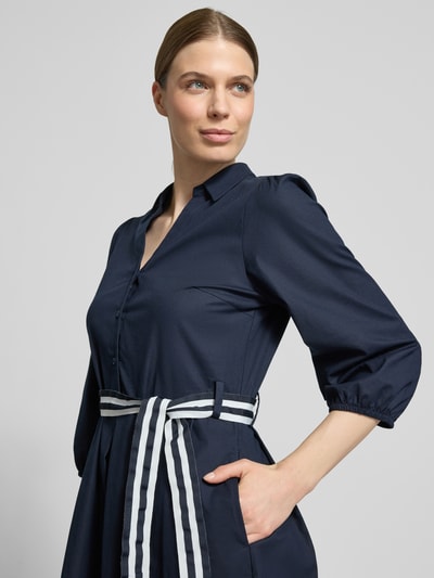 Frauenmodel trägt Hemdblusenkleid mit V-Ausschnitt und Bindegürtel von More & More in Dunkelblau, Baumwoll-Elasthan-Mix, Nahaufnahme Oberkörper.