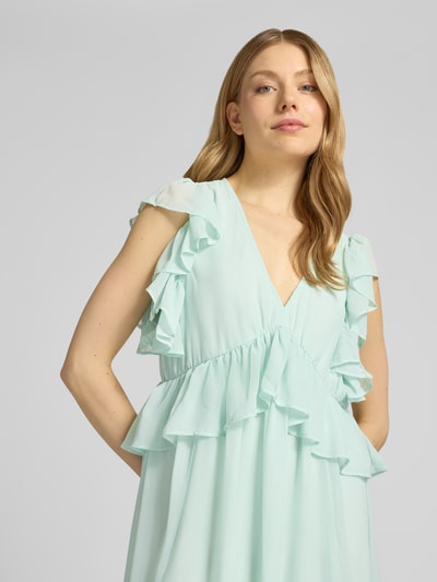 Frauenmodel trägt Cocktailkleid mit Volants Modell 'MUSSI' von YAS in Mint, fließender Stoff, V-Ausschnitt, Nahaufnahme Oberkörper. Midikleid, Gerader-Schnitt, Rückenlänge bei Größe 36: 138 cm, Brustweite: 46 cm.