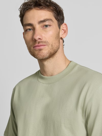 Männermodel trägt Regular Fit T-Shirt aus reiner Baumwolle Modell 'DAPOLINO' von HUGO, Optik: Unifarben, Label-Schriftzug, Nahaufnahme Oberkörper.