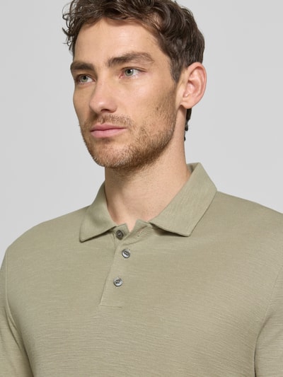 Männermodel trägt Slim Fit Poloshirt aus Lyocell-Leinen-Mix Modell 'DULINEN' von HUGO, Optik: Unifarben, Label-Applikation, Nahaufnahme Oberkörper.