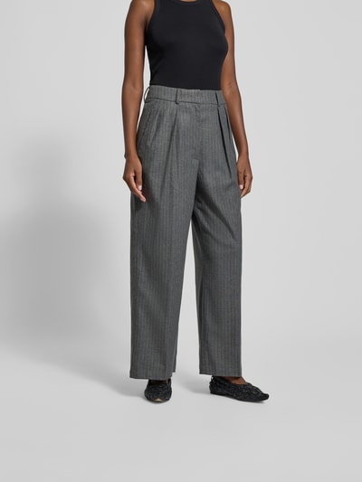 Frauenmodel trägt Stoffhose mit Bundfalten von black palms aus Material-Mix mit Viskose-Anteil, Lockerer-Schnitt, Nahaufnahme Oberkörper.