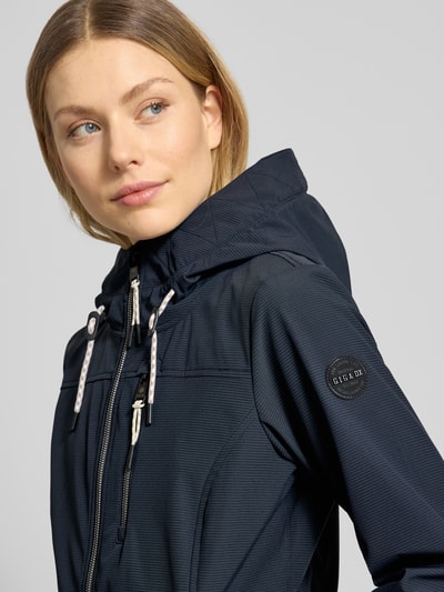 Frauenmodel trägt Jacke mit 10.000 mm Wassersäule Modell 'GS111' von G.I.G.A. DX in Dunkelblau, sichtbare Kapuze, Reißverschluss, Reißverschlusstaschen, Slim Fit, dezente Struktur, Nahaufnahme Oberkörper