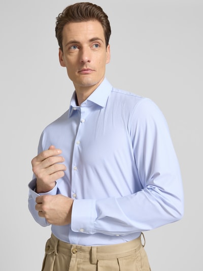 Männermodel trägt Slim Fit Business-Hemd mit Kentkragen von Jake*s in Hellblau, Elastischer-Material-Mix, Langärmelig, Knopfleiste, Nahaufnahme Oberkörper.