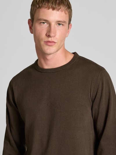 Męski model nosi longsleeve mit rundhalsausschnitt von Jack & Jones z bawełny, prosty krój, detal z logo, prążkowane wykończenia, zbliżenie na górną część ciała