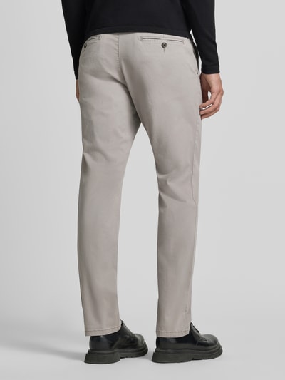 Męski model nosi Hose mit Gesäßtaschen von Christian Berg Men, mieszanka bawełny i elastanu, krój slim fit, wpuszczane kieszenie, jasnoszary, szerokość w rozmiarze 50: 45 cm, długość wewnętrzna nogawki w rozmiarze 50: 80 cm, widok całej sylwetki od tyłu.