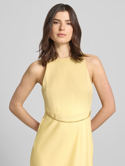Frauenmodel trägt Maxikleid mit Ketten-Detail von ARMANI EXCHANGE aus gelbem Satin, taillierter Schnitt, Rundhalsausschnitt, Nahaufnahme Oberkörper.