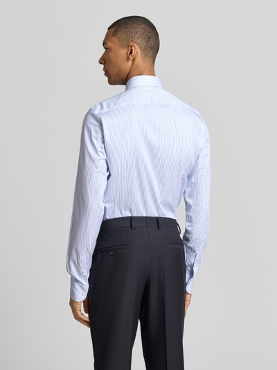Männermodel trägt Slim Fit Businesshemd mit extra langem Arm Modell 'H-HANK' von BOSS, blau-weiß gestreift, Ganzkörperansicht Rückansicht.