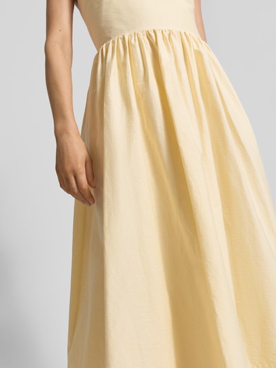 Frauenmodel trägt Midikleid mit Eingrifftaschen Modell 'COVER' von SUNCOO PARIS aus Baumwoll-Mix, A-Linie, Nahaufnahme Oberkörper.