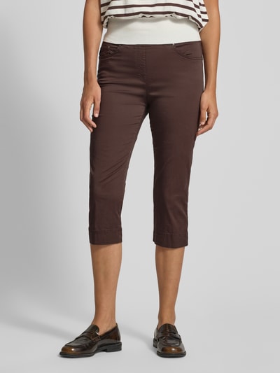 Kobiece model nosi Slim Fit Caprihose aus Baumwoll-Mix od Raphaela By Brax, efekt: jednolity kolor, krój slim fit, ściągacz, 5 kieszeni, mieszanka bawełny, całkowite ujęcie z przodu.