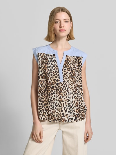 Frauenmodel trägt Relaxed Fit Bluse aus reiner Viskose mit Allover-Animal-Print von Emily Van den Bergh, beige-braune Muster, Tunika-Ausschnitt, ärmellos, leichte Struktur, Ganzkörperansicht von vorne.
