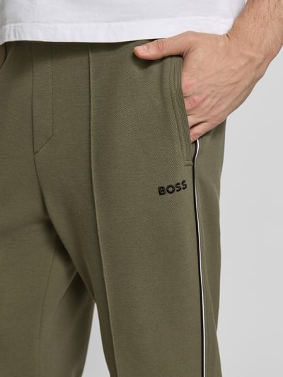 Männermodel draagt Regular Fit Sweatpants uit katoenmix model 'JOIN HADIKO' van BOSS Green, effen look, piqué, detailopname heup.