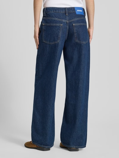 Kobiece modelka nosi ciemnoniebieskie jeansy o kroju loose fit z bawełny, Loose Fit Jeans aus reiner Baumwolle Modell 'LENI' 'GAMALA_B' od Hugo Blue, prosta nogawka, wyraziste szwy, damskie straight fit jeans, widok całej sylwetki z tyłu.