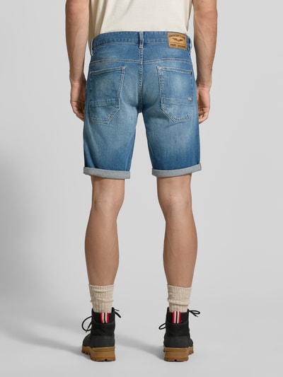 Männermodel trägt Regular Fit Jeansshorts im 5-Pocket-Design von PME Legend aus Baumwoll-Elasthan-Mix, Modell NIGHTFLIGHT, Ganzkörperansicht Rückansicht. Bundweite bei Größe 32: 43 cm, Innenbeinlänge: 25 cm, Knopf- und Reißverschluss, blaue Denim-Struktur.