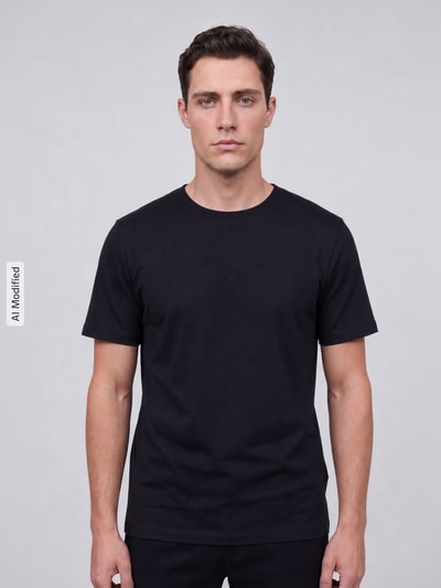 Männermodel trägt Regular Fit T-Shirt mit Rundhalsausschnitt von MCNEAL aus reiner Baumwolle in Schwarz, Ganzkörperansicht von vorne.