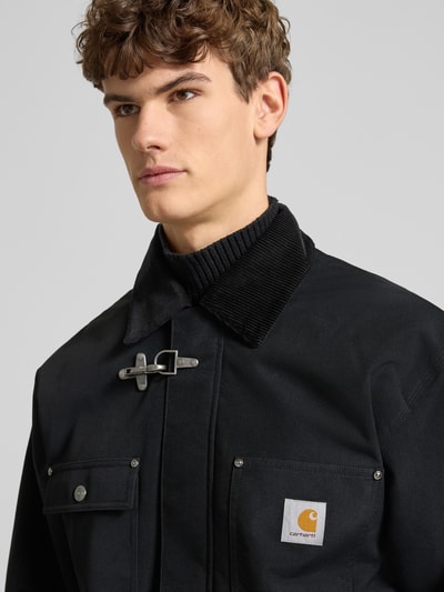 Männermodel trägt Oversized Jacke mit Logo-Patch Modell 'Adair' von Carhartt Work In Progress in Schwarz, Cord-Kragen, Nahaufnahme Oberkörper