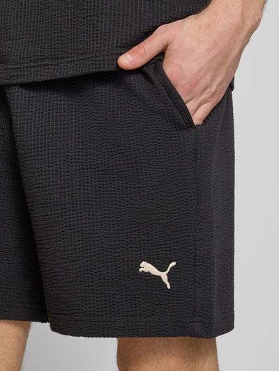 Männermodel trägt Shorts mit Logo-Stitching von PUMA PERFORMANCE aus Reine Baumwolle mit Strukturmuster, Gerader-Schnitt, Nahaufnahme Oberschenkel.