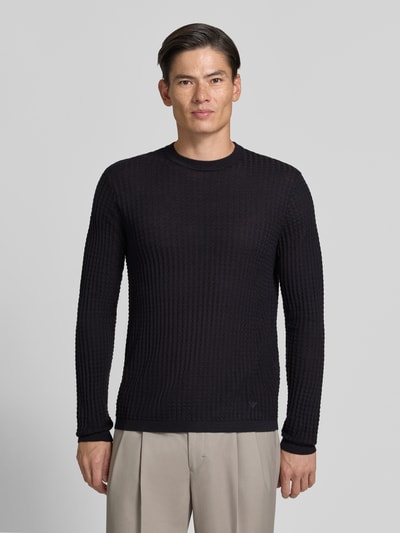 Männermodel trägt Strickpullover mit Struktur-Muster von Emporio Armani in Schwarz, Rundhalsausschnitt, Material-Mix mit Woll-Anteil, taillierter Schnitt, Ganzkörperansicht von vorne.