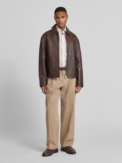 Männermodel trägt Regular Fit Businesshemd aus reiner Baumwolle mit Kentkragen von OLYMP, beige Stoff, kombiniert mit brauner Jacke und Hose, Ganzkörperansicht von vorne.