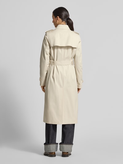 Vrouwenmodel draagt Slim Fit Trenchcoat aus reiner Baumwolle van Tommy Hilfiger in uni beige, lange mouwen, twill textuur, achteraanzicht hele lichaam.