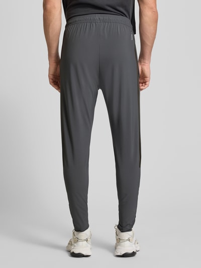 Männermodel trägt Regular Fit Jogpants mit elastischem Bund Modell 'TIRO' von adidas Sportswear, grauer Ton, Ganzkörperansicht Rückansicht