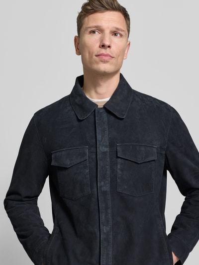 Männermodel trägt Lederjacke mit Kentkragen Modell 'Atorn' von JOOP! Collection aus Ziegenvelours, Regular Fit, Nahaufnahme Oberkörper.
