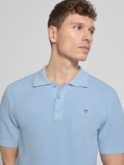 Männermodel trägt Regular Fit Poloshirt mit Label-Stitching von Gant in Hellblau aus reiner Baumwolle, Nahaufnahme Oberkörper.