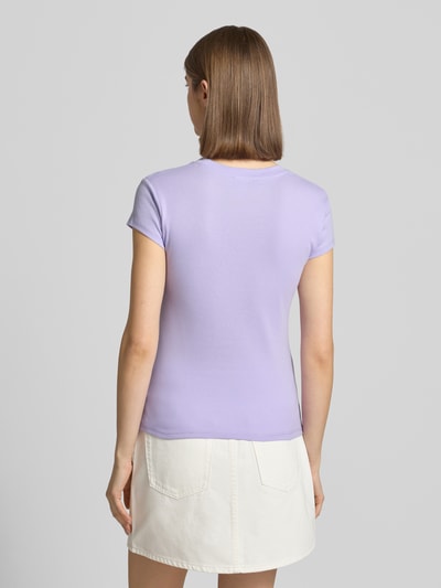 Vrouwenmodel draagt T-Shirt met Rundhalsausschnitt Modell 'EVERYDAY' van Topshop, katoenmix, slim fit, lichtpaars op witte rok, ruglengte maat S 54 cm, volledige achteraanzicht.