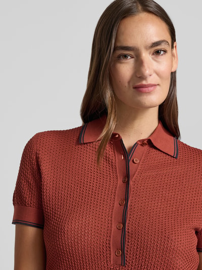 Vrouwenmodel draagt gebreid shirt van puur katoen in regular fit, model 'MEROPE' van DRYKORN met polokraag en knoopsluiting, nahaufnahme bovenlichaam.