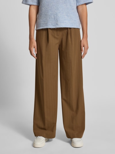 Frauenmodel trägt Wide Fit Stoffhose mit französischen Eingrifftaschen Modell 'SYSTECK' von Mango in Braun, Material-Mix, Ganzkörperansicht von vorne.