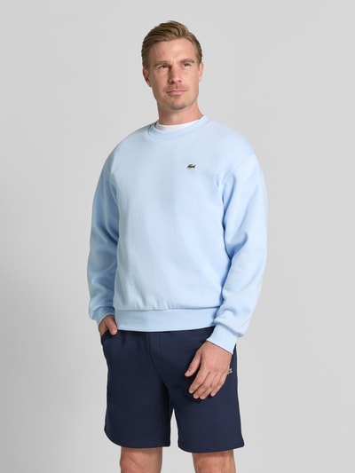 Mężczyzna nosi Regular Fit Sweatshirt aus Baumwoll-Mix od Lacoste w jasnoniebieskim kolorze, gładka faktura, Ganzkörperansicht von vorne.