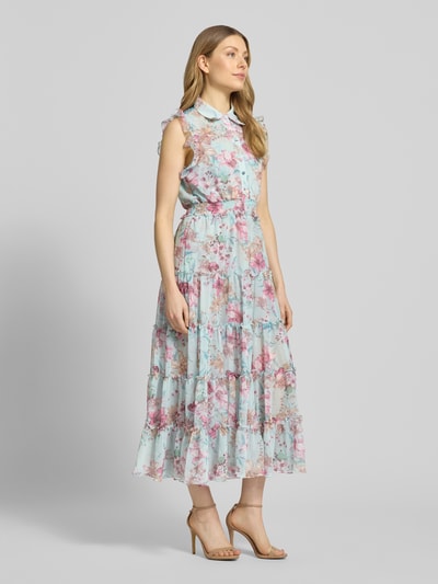 Frauenmodel trägt Regular Fit Maxikleid mit Rüschenbesatz von ADLYSH, floraler Allover-Print, Umlegekragen, Knopfleiste, Taillierte Passform, Ärmelloses-Design, sanfte Pastellfarben, luftige Stofftextur, Ganzkörperansicht von vorne.