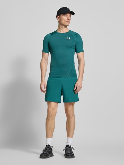 Männermodel trägt Slim Fit T-Shirt mit Logo-Print von Under Armour in Türkis, Elastischer-Material-Mix, Rundhalsausschnitt, Ganzkörperansicht von vorne. Herren T-Shirt, Rückenlänge bei Größe M: 62 cm.