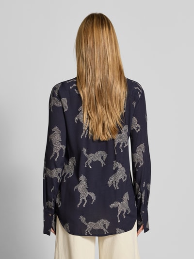 Frauenmodel trägt Relaxed Fit Bluse aus reiner Viskose Modell 'ODETTA' von ODETTA, dunkler Allover-Motiv-Print, Rückenansicht.