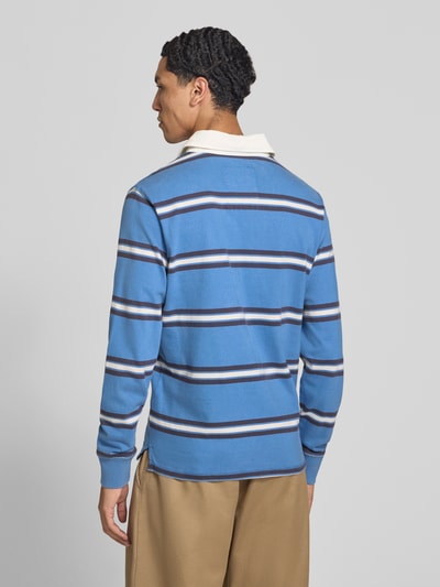 Männermodel trägt Poloshirt aus reiner Baumwolle von Superdry in Blau mit weißen und schwarzen Streifen, gerader Schnitt, Rückenansicht.