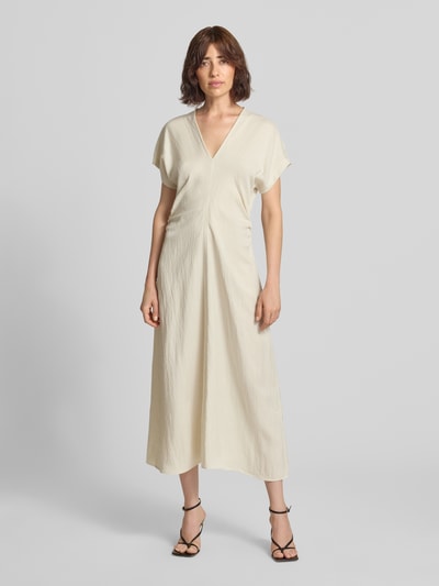 Vrouwenmodel draagt Regular Fit Maxikleid uit lyocellmix met viscose van Jake*s Collection, V-hals, plooien, met korte mouwen, kleur crème, ruglengte maat 36: 130 cm, borstwijdte 53 cm, mouwlengte 28 cm, geheel te zien van voren.