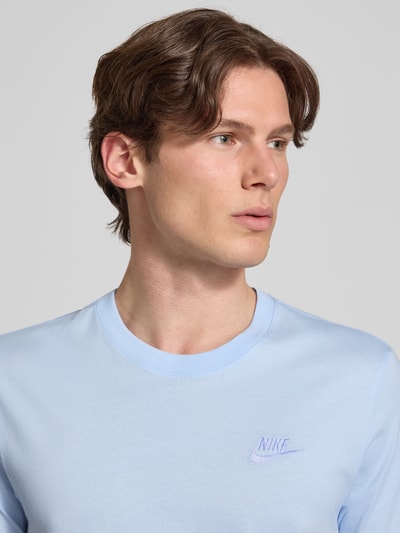 Männermodel trägt T-Shirt mit Label-Stitching von Nike in Hellblau aus Reine Baumwolle, Regular-Fit, Rundhalsausschnitt, Nahaufnahme Oberkörper.