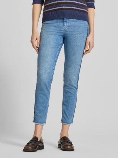 Frauenmodel trägt Slim Fit Jeans aus Baumwoll-Mix Modell 'Ornella' von Angels in Hellblau mit Galonstreifen und ausgefransten Beinabschlüssen, 7/8-Länge, 5-Pocket-Design, Ganzkörperansicht von vorne.