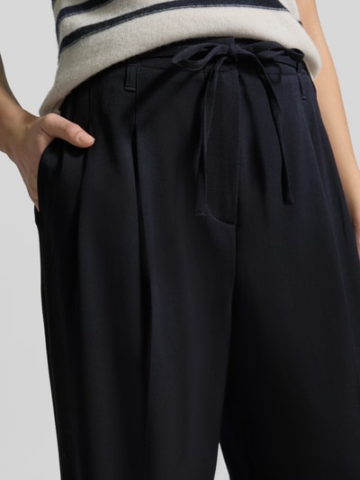 Mädchen trägt Hose mit weitem Bein und Bindegürtel von Zero, materiał z domieszką wiskozy, szerokie nogawki, szerokość w rozmiarze 36: 45 cm, długość wewnętrzna nogawki w rozmiarze 36: 79 cm, zbliżenie na górną część ciała.