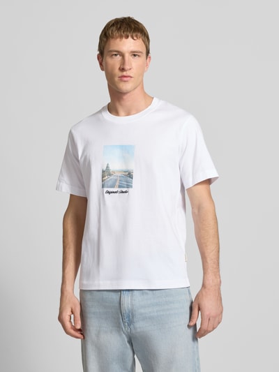 Männermodel draagt T-shirt met ronde hals 'JORNORREBRO' van Jack & Jones, rechte fit, puur katoen, wit, fotoprint voorzijde, bovenlichaam close-up, vooraanzicht.