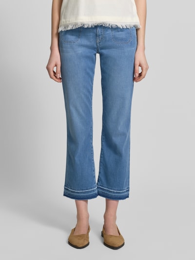 Frauenmodel trägt Straight Leg Jeans mit Fransensaum von Marc Cain, hellblaue Denim, Baumwoll-Mix mit Lyocell-Anteil, Nahaufnahme Oberkörper.